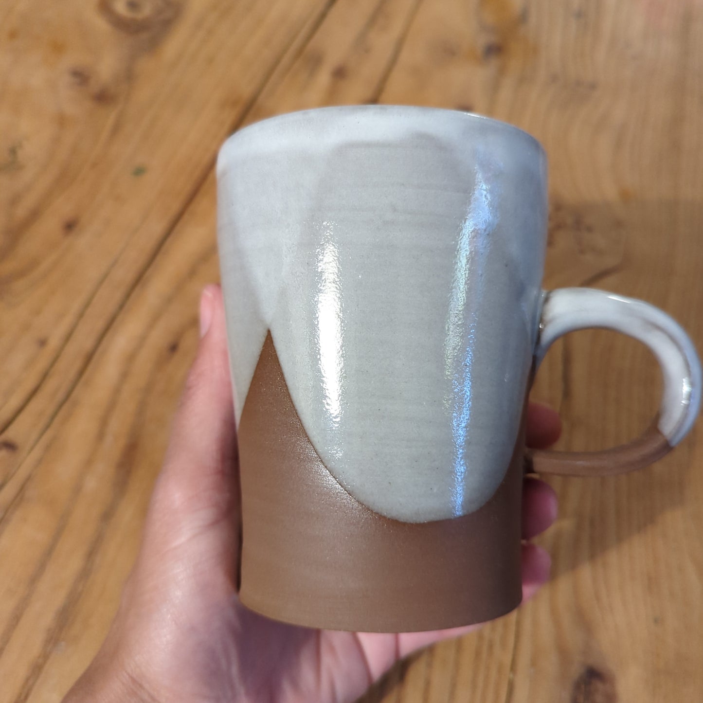White glaze curves on red clay mug