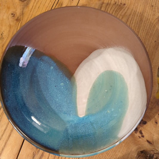 Red clay serving dish with blue and white curves